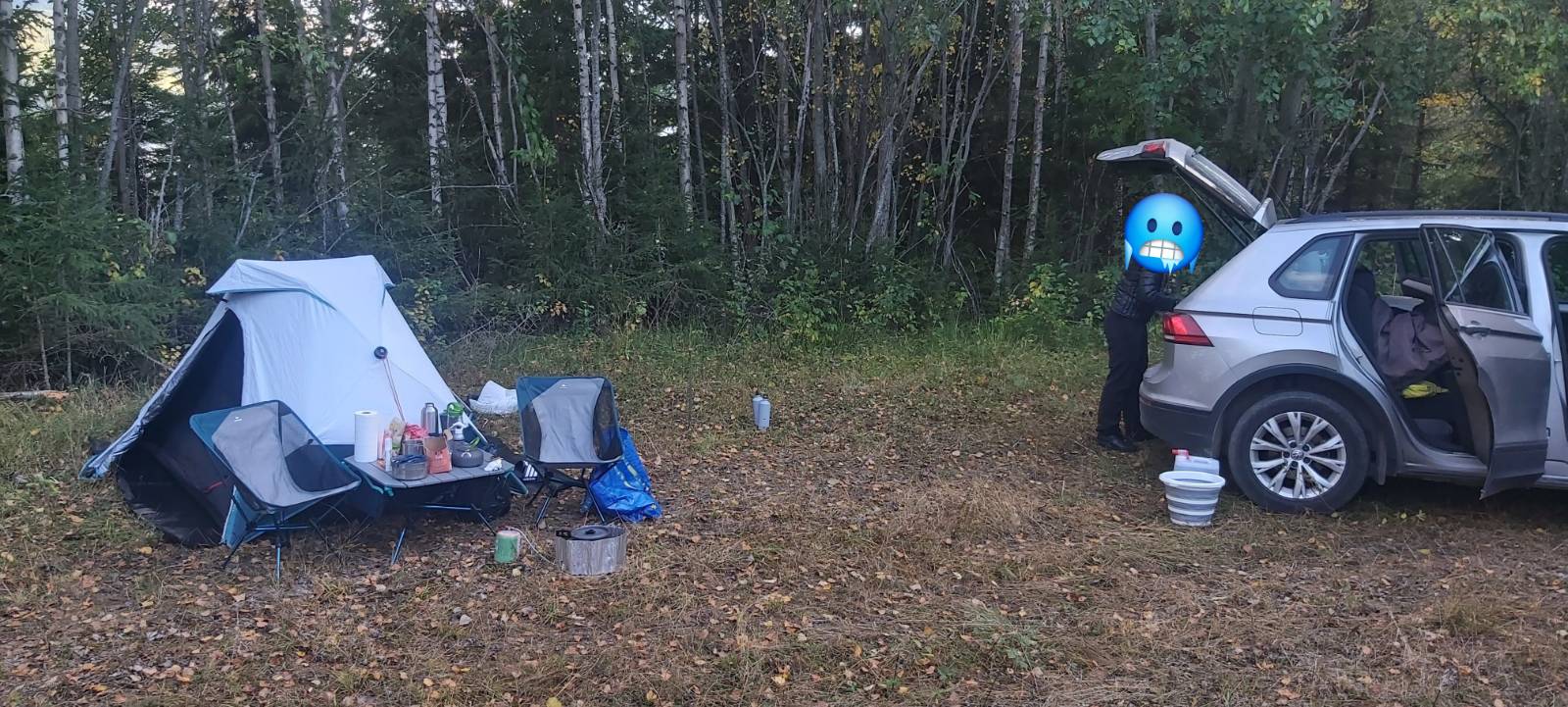 samochód zaparkowany na polanie obok lasu, kilka metrów obok samochodu rozbity namiot