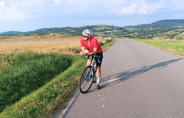 rowerzysta zatrzymał się na poboczu pustej, malowniczej drogi