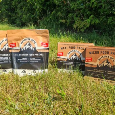cztery racje żywnościowe Maverick Food Package ustawione na trawniku