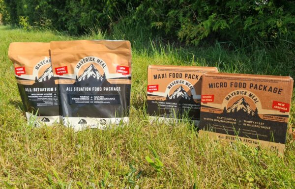 cztery racje żywnościowe Maverick Food Package ustawione na trawniku
