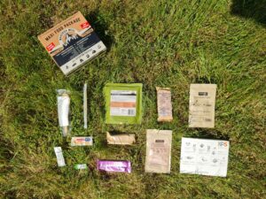 Zawartość zestawu Maxi Food Package ułożona na trawniku, łącznie 12 elementów