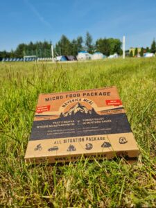 Tekturowe opakowanie Micro Food Package od Maverick Meal położone na trawie